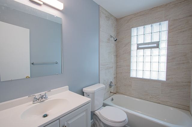 full bathroom with vanity, toilet, and tiled shower / bath