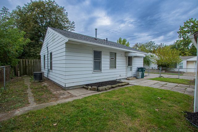 view of front of property with a front yard and cooling unit