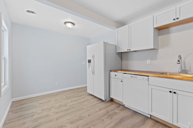 kitchen with wood counters, sink, white appliances, and white cabinets