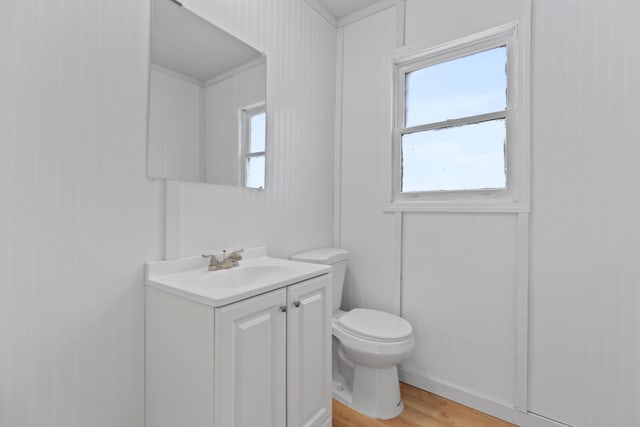 bathroom with hardwood / wood-style flooring, vanity, and toilet