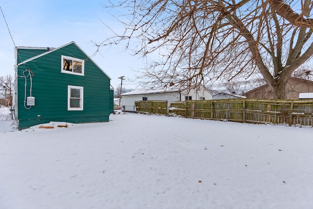 view of snow covered back of property