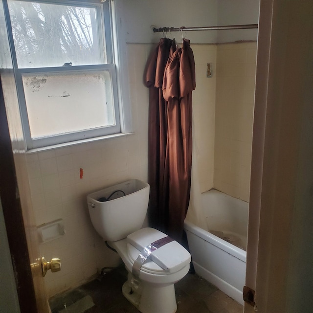 bathroom featuring toilet and shower / bath combo with shower curtain