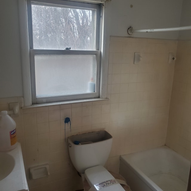 bathroom featuring tile walls, toilet, and a bathing tub