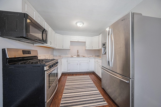 kitchen featuring stainless steel appliances, sink, white cabinets, and dark hardwood / wood-style flooring