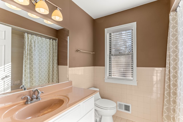 bathroom with tile patterned floors, toilet, tile walls, vanity, and a shower with shower curtain