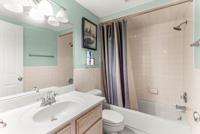 full bathroom with shower / bath combination with curtain, vanity, toilet, and tile walls