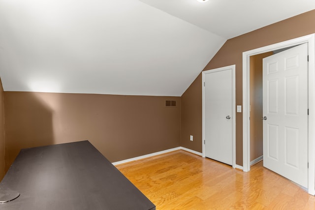 bonus room with lofted ceiling and light hardwood / wood-style floors