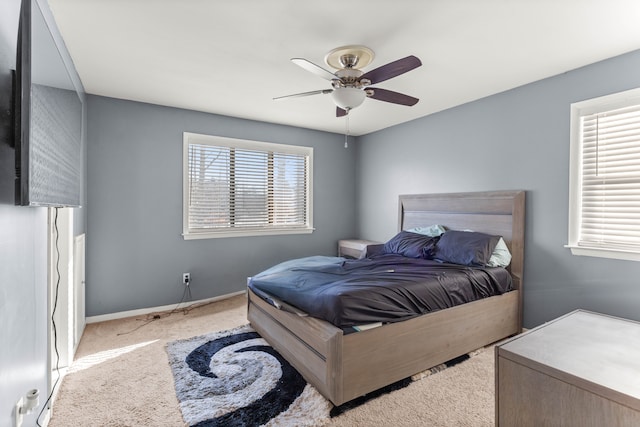 bedroom featuring multiple windows, light colored carpet, and ceiling fan