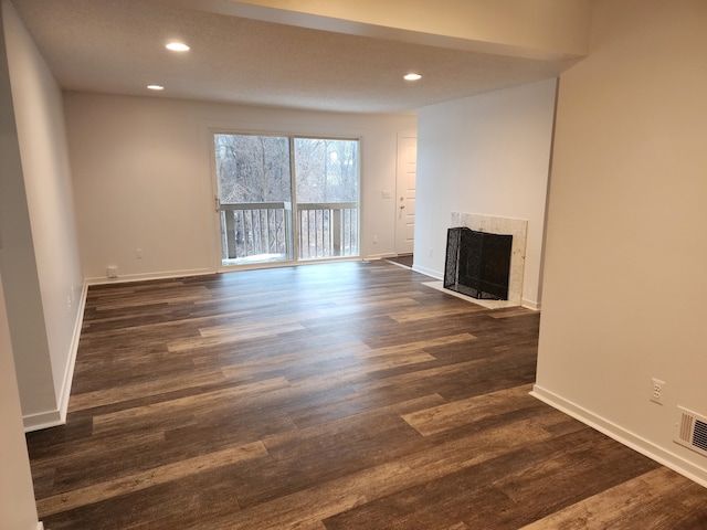 unfurnished living room with a high end fireplace and dark hardwood / wood-style flooring