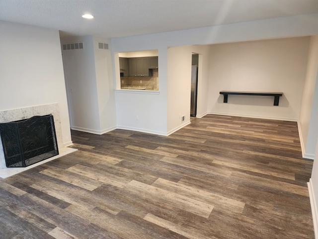 unfurnished living room with dark wood-type flooring and a fireplace