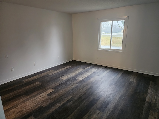 spare room with dark hardwood / wood-style flooring