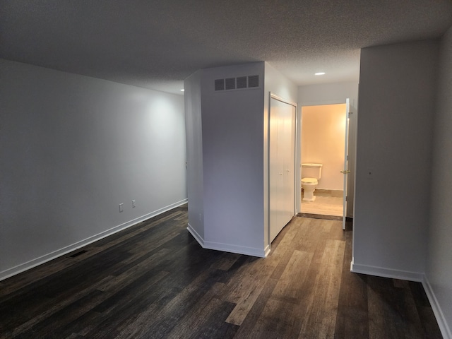 corridor featuring dark wood-type flooring and a textured ceiling