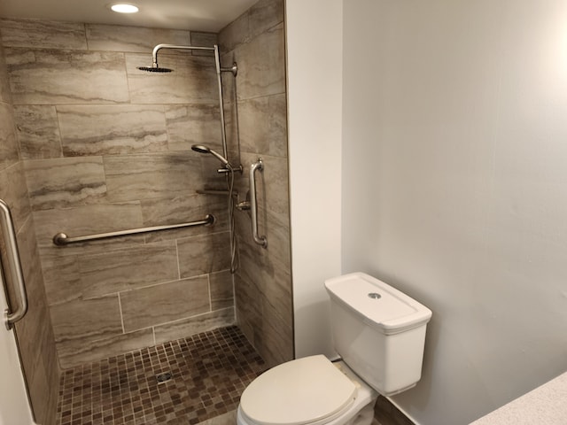 bathroom with toilet and a tile shower