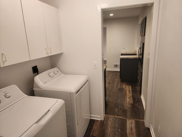 laundry area with dark hardwood / wood-style flooring, cabinets, and independent washer and dryer