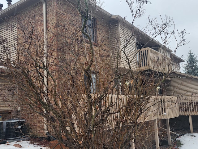 snow covered property featuring a balcony and central air condition unit