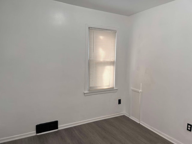 unfurnished room featuring dark wood-type flooring