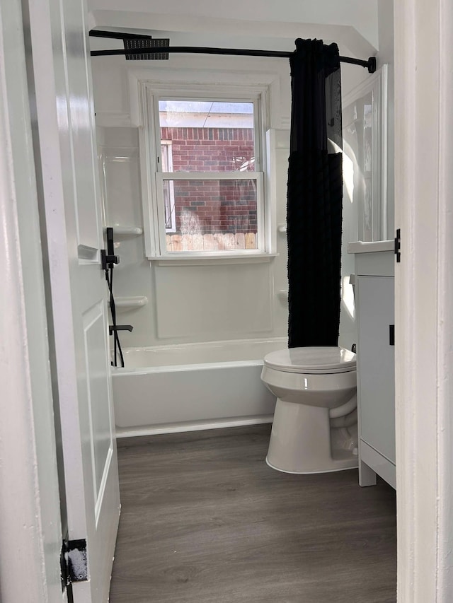 bathroom with shower / bath combo, hardwood / wood-style floors, and toilet