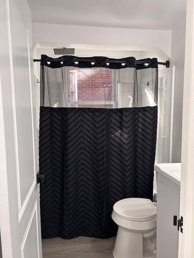 bathroom featuring vanity, toilet, curtained shower, and hardwood / wood-style floors