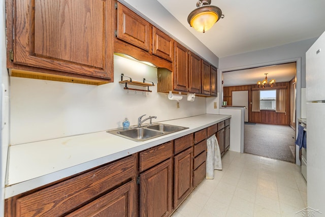 kitchen featuring pendant lighting, sink, a notable chandelier, and stainless steel electric stove