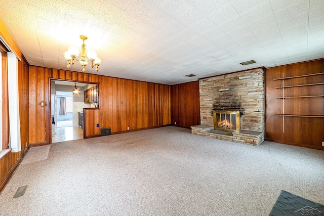 unfurnished living room featuring built in shelves, a fireplace, and wooden walls