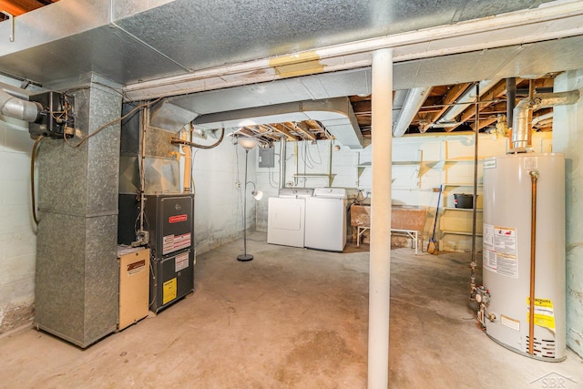 basement featuring electric panel, washer and clothes dryer, heating unit, and gas water heater