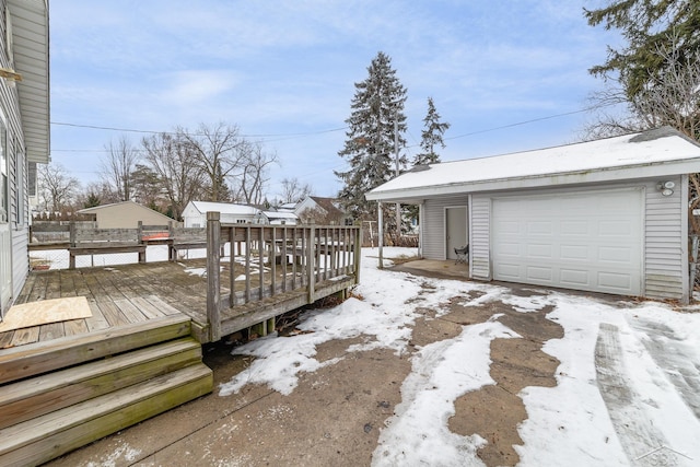 snow covered deck with a garage and an outdoor structure