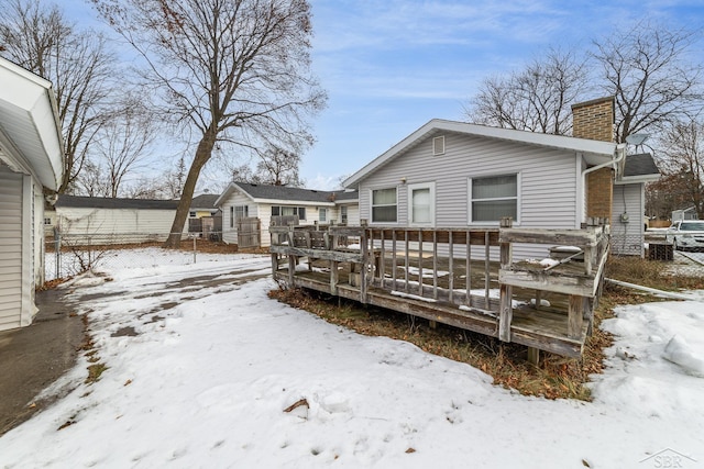 snow covered property featuring a wooden deck