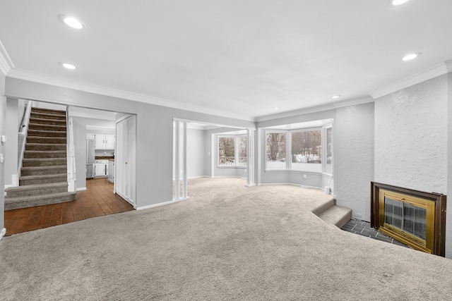 unfurnished living room with crown molding, a fireplace, and dark carpet