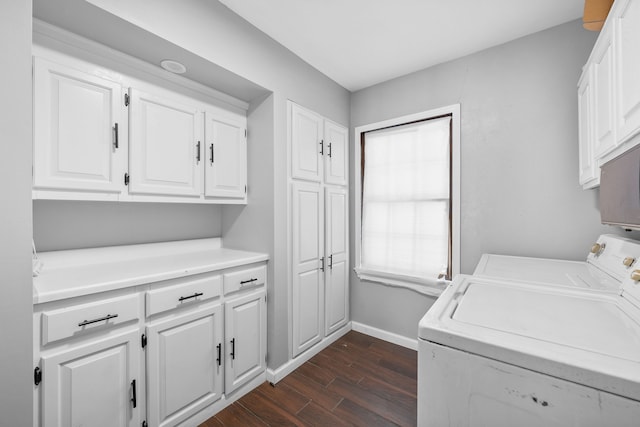 washroom with dark hardwood / wood-style flooring, washing machine and dryer, and cabinets