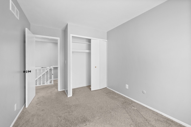 unfurnished bedroom featuring a closet and light carpet