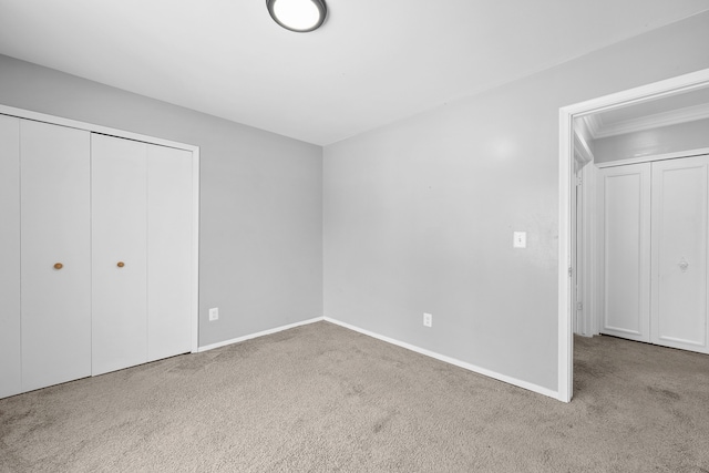 unfurnished bedroom featuring light carpet and a closet