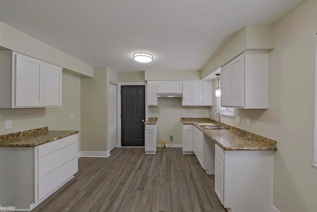 kitchen featuring white cabinetry, sink, light wood-type flooring, and dark stone counters