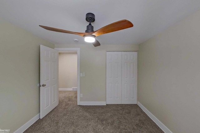 unfurnished bedroom with ceiling fan, carpet floors, and a closet