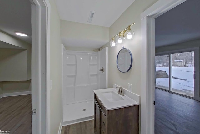 bathroom featuring vanity, wood-type flooring, and a shower