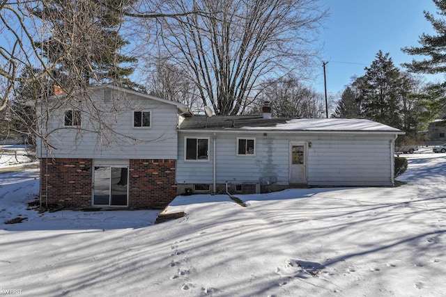 view of snow covered rear of property