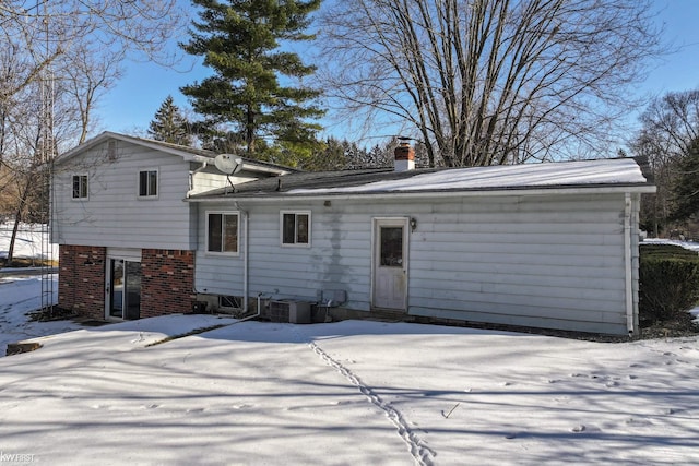 snow covered property featuring central AC