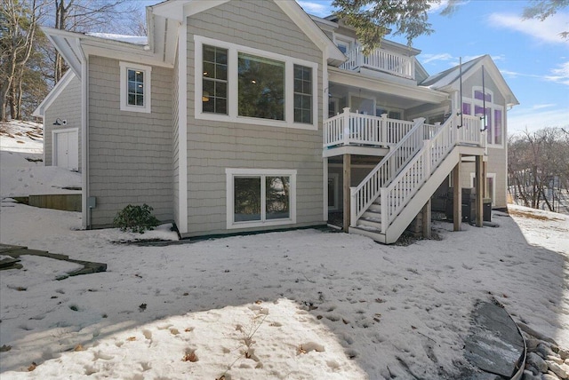 snow covered house featuring a balcony