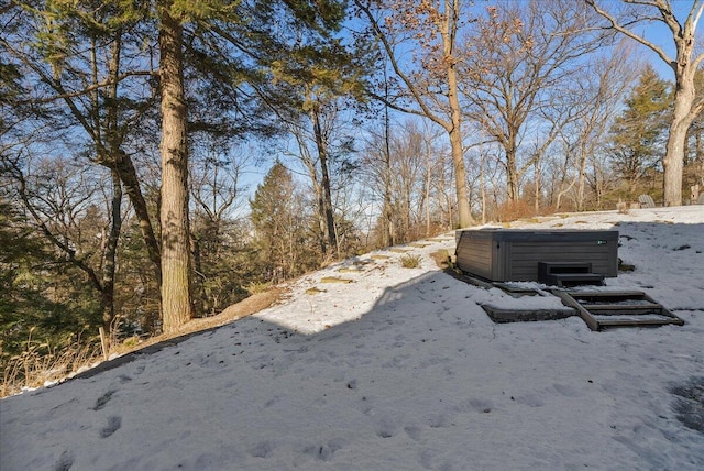 yard covered in snow featuring a hot tub