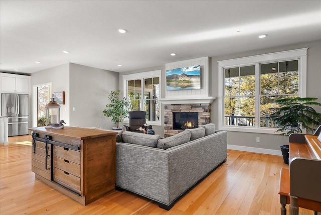 living room with a fireplace and light wood-type flooring