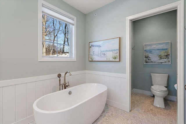 bathroom featuring toilet, tile patterned flooring, and a bathtub