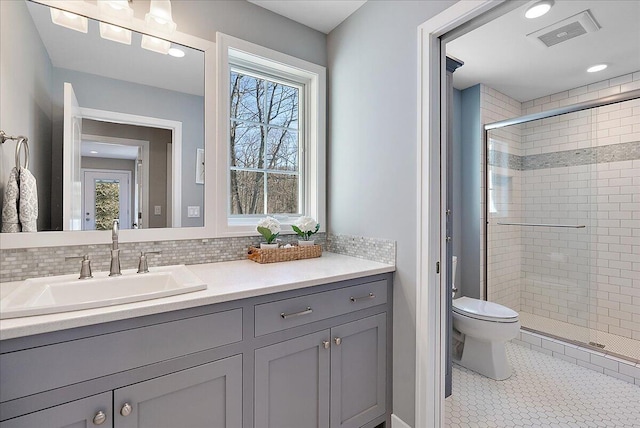 bathroom with tile patterned floors, toilet, an enclosed shower, tasteful backsplash, and vanity