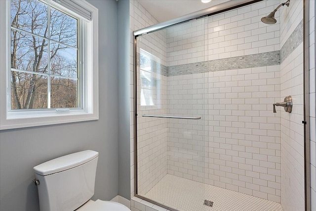 bathroom with a shower with door and toilet