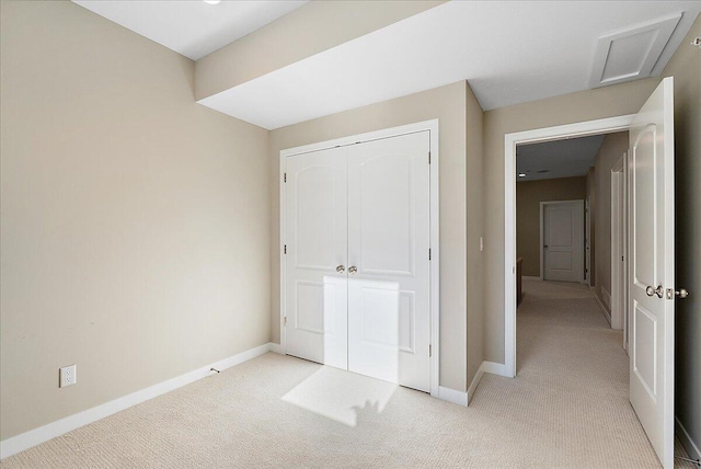 unfurnished bedroom featuring light carpet and a closet