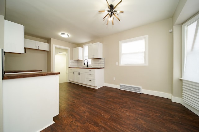 kitchen with white cabinetry, sink, decorative backsplash, and dark hardwood / wood-style floors