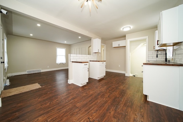 kitchen with tasteful backsplash, white cabinetry, sink, and dark hardwood / wood-style floors