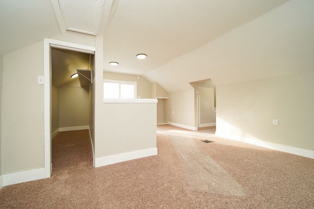 additional living space featuring lofted ceiling and light colored carpet