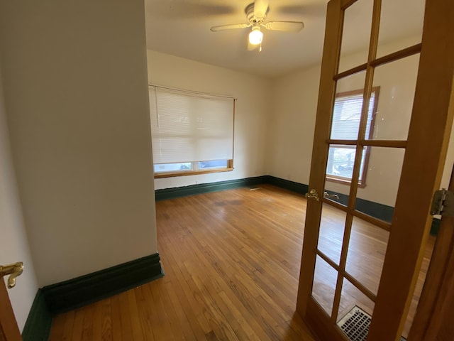 spare room with hardwood / wood-style floors and ceiling fan