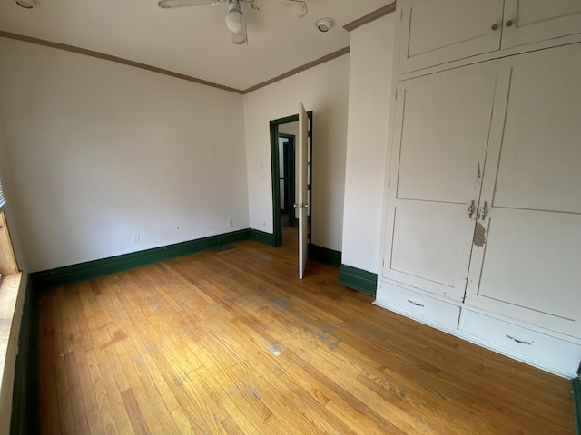 unfurnished bedroom with crown molding, a closet, and light hardwood / wood-style flooring