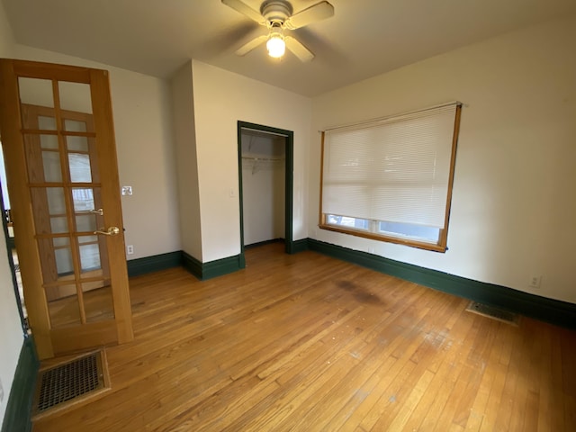 unfurnished bedroom with ceiling fan, hardwood / wood-style floors, and a closet