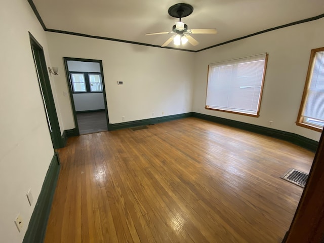 empty room with crown molding, ceiling fan, and hardwood / wood-style floors